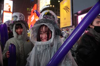 Orang-orang yang bersuka ria menunggu di tengah hujan di Times Square untuk menyaksikan pesta bola tengah malam untuk merayakan Malam Tahun Baru pada 31 Desember 2024 di New York City.